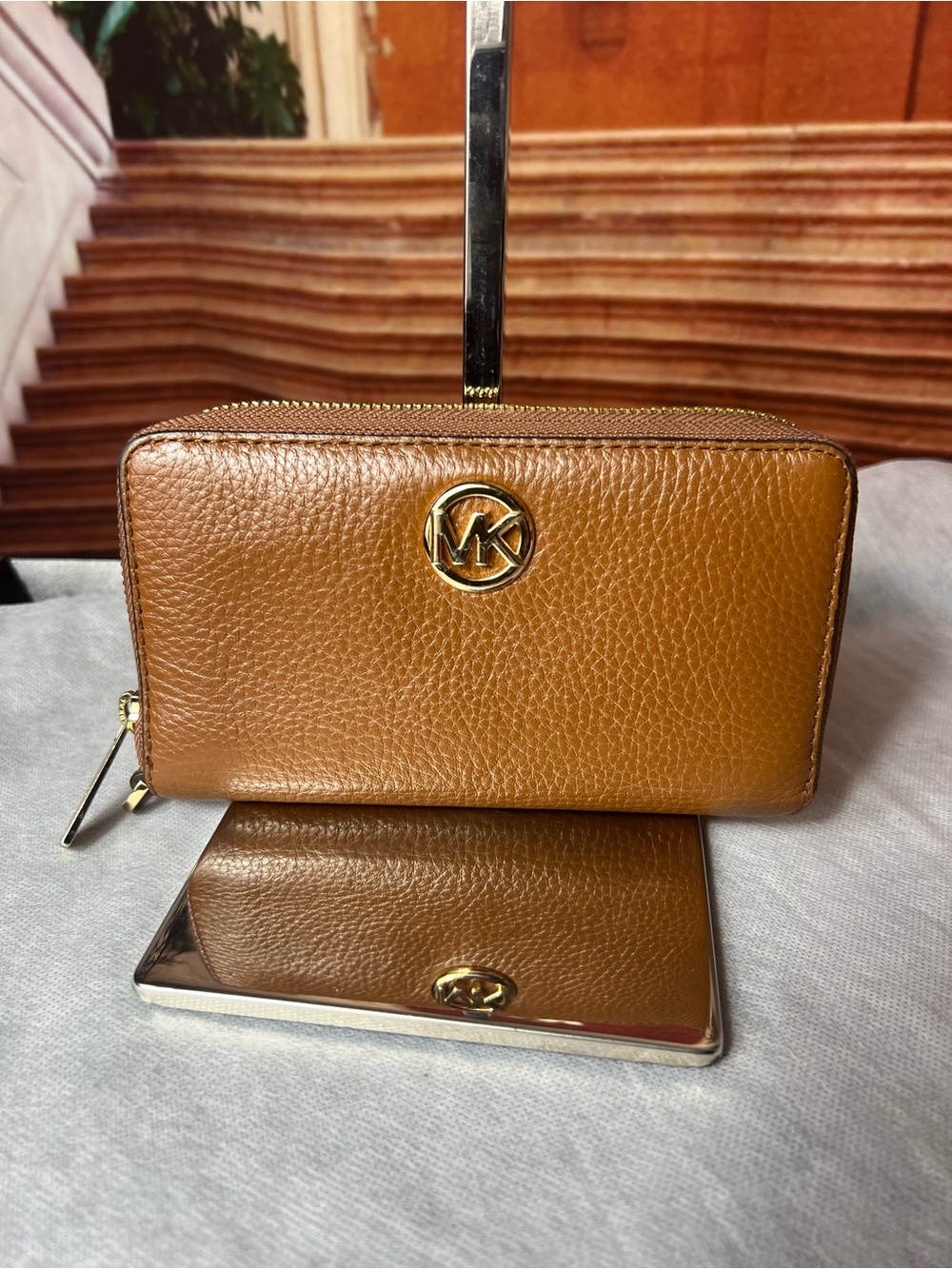 Michael Kors Fulton pebbled leather wristlet features signature gold-tone logo